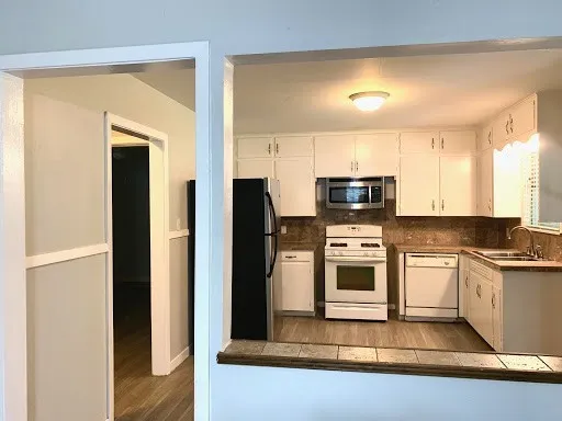 a kitchen with stainless steel appliances granite countertop a stove a sink and a refrigerator