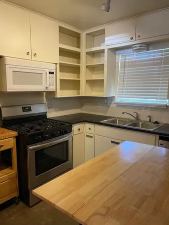 a kitchen with a stove a sink and a microwave