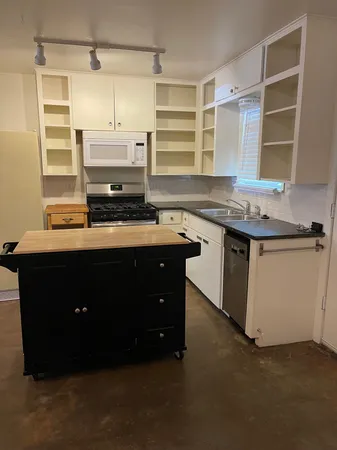 a kitchen with a sink a stove and cabinets