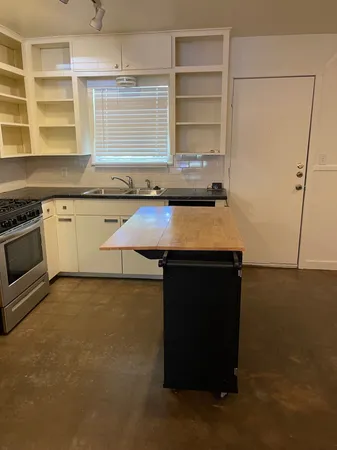 a kitchen with granite countertop a sink a stove and a microwave