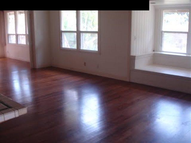 108 Kalipo Place Haiku, HI 96708 - Photo 3 of 6 an empty room with wooden floor and windows