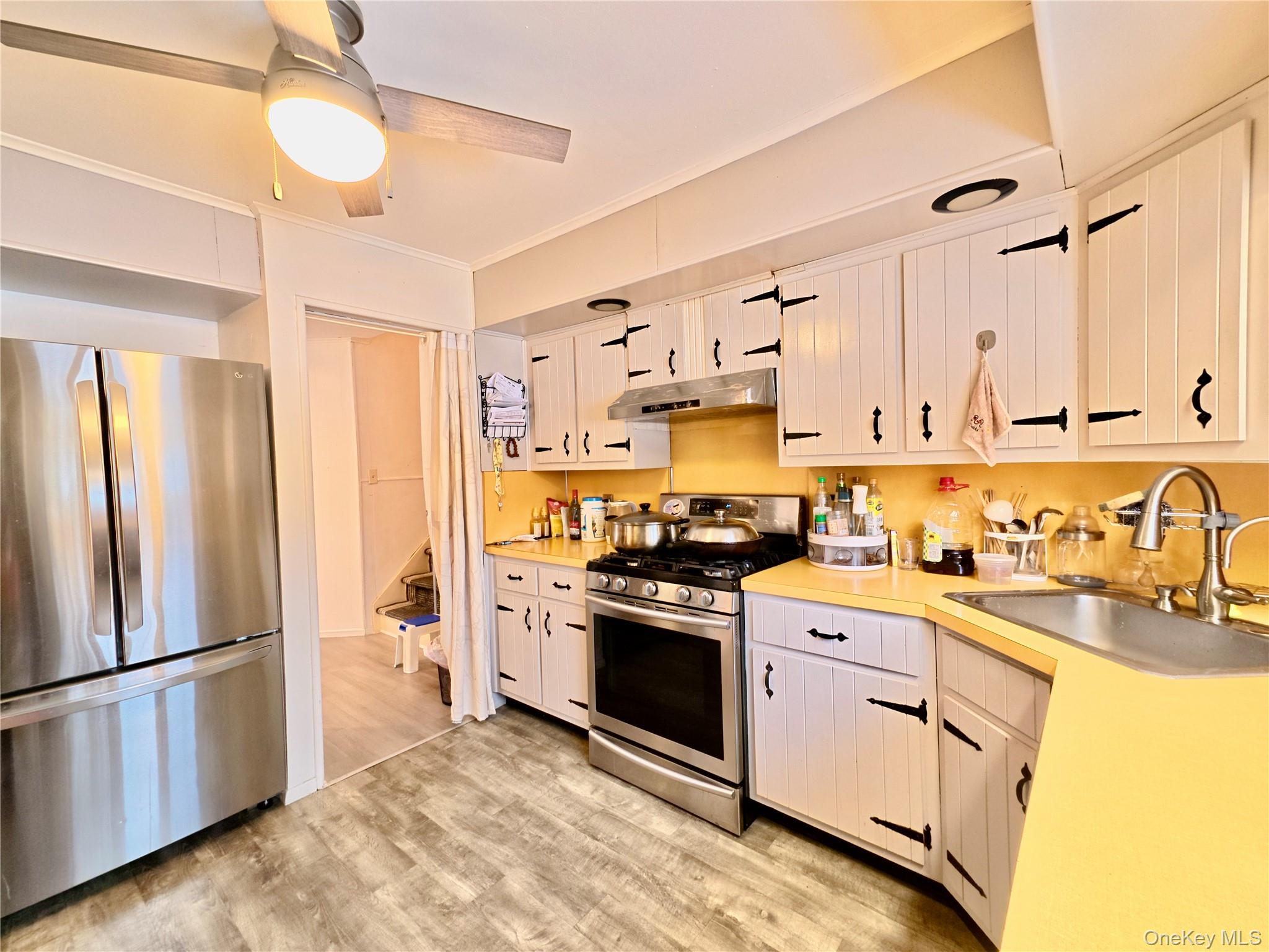 10 Kings Park Road Commack, NY 11725 - Photo 8 of 29 a kitchen with stainless steel appliances a refrigerator sink and cabinets