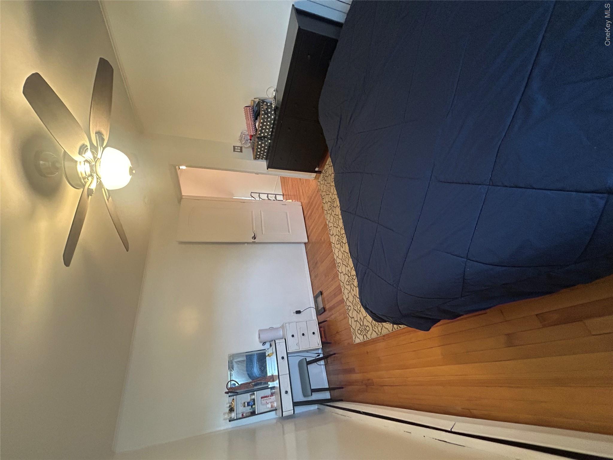 10 Kings Park Road Commack, NY 11725 - Photo 10 of 29 a bedroom with a bed and a chandelier