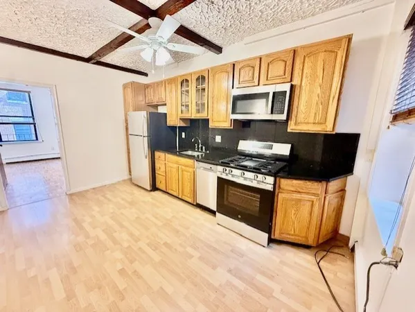 a kitchen with stainless steel appliances granite countertop a stove top oven a sink a counter space and cabinets