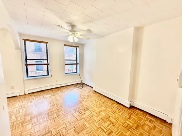 a view of a room with wooden floor and ceiling fan