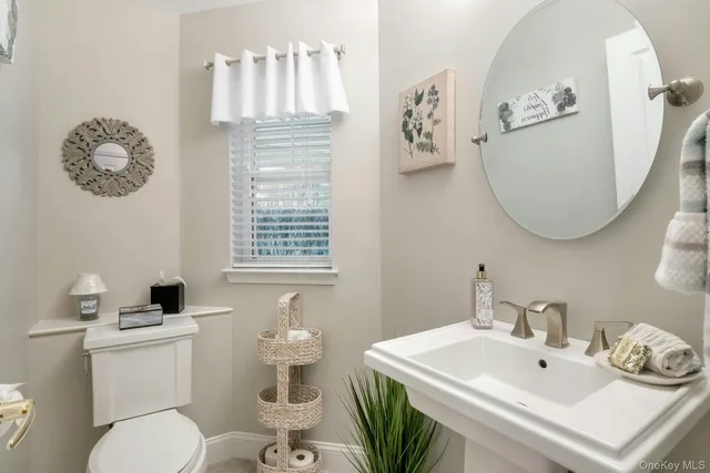 a bathroom with a toilet a sink and a mirror