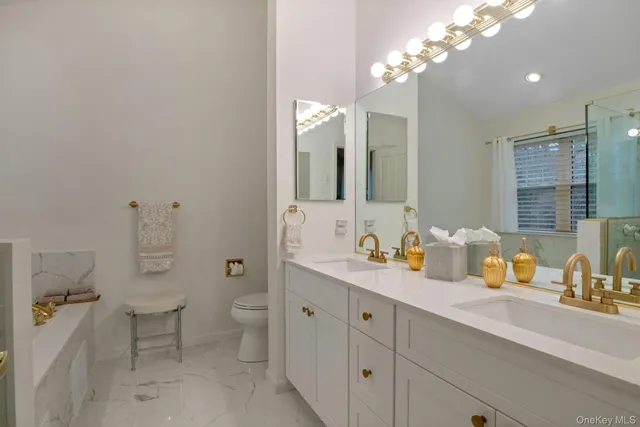 a spacious bathroom with a double vanity sink toilet and a mirror