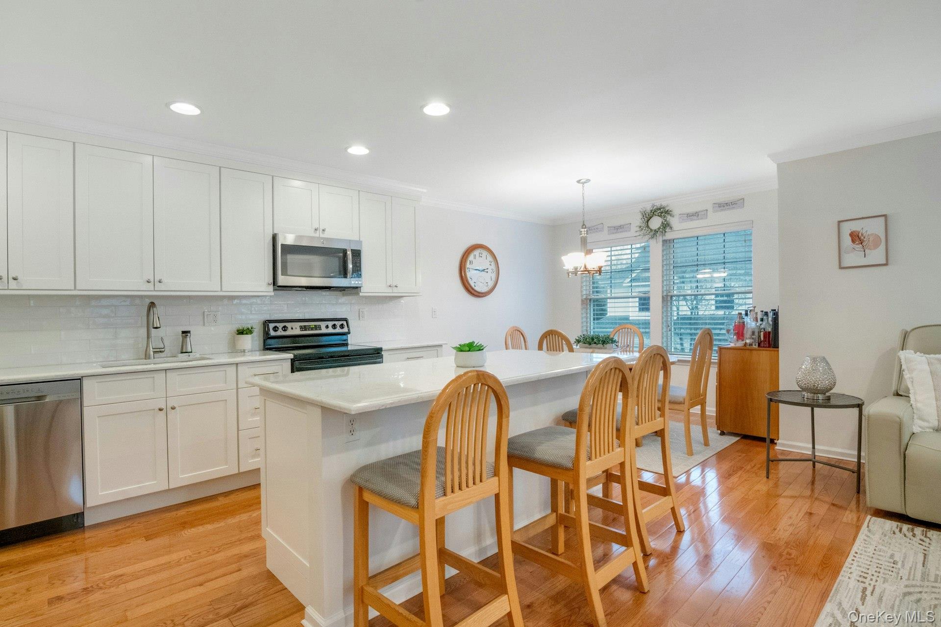 118 Underhill Lane Peekskill, NY 10566 - Photo 10 of 33 Kitchen with center island, custom white cabinetry, quartz counter tops, stainless appliances and tiled backsplash.