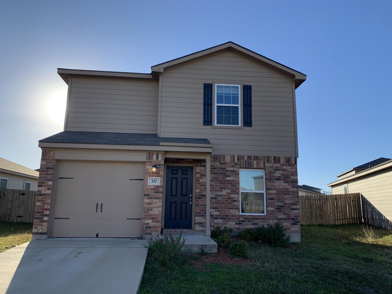 217 Denson Lane Jarrell, TX 76537 - Photo 1 of 26 Two-story residence featuring a brick and siding exterior, an attached single-car garage, and a covered entry