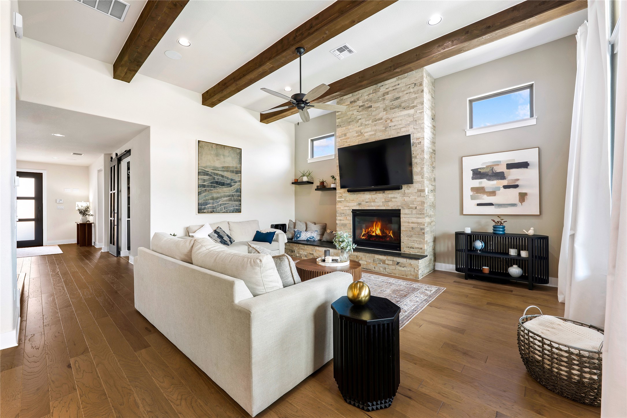 2408 Nate's Place Georgetown, TX 78633 - Photo 6 of 40 Living area featuring exposed beams and a stacked stone fireplace anchor this inviting living space, perfect for gathering.