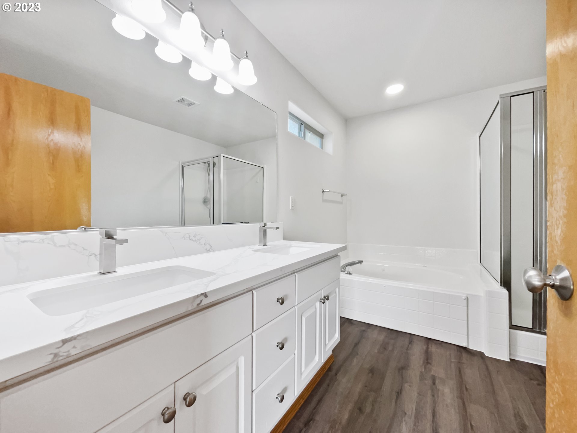 170 Southwest Sandlewood Loop Gresham, OR 97030 - Photo 11 of 19 a bathroom with a double vanity sink a mirror and a bathtub