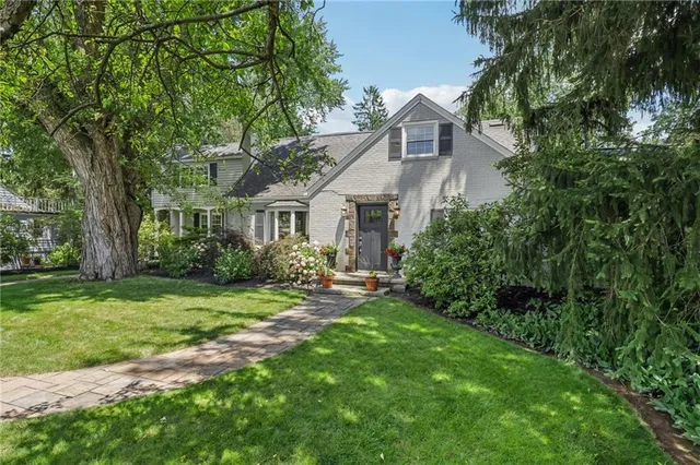 a view of a house with a big yard plants and large trees