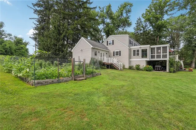 a front view of a house with a garden and trees
