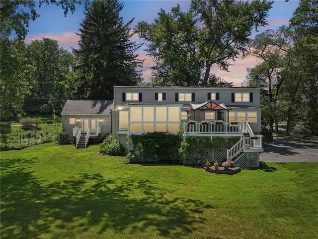 a view of a house with backyard and a tree