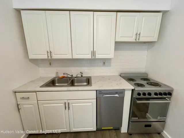 a kitchen with granite countertop a sink a stove and cabinets