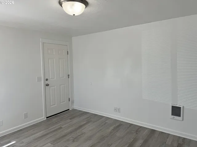 a view of an empty room with wooden floor