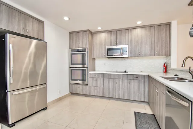 a kitchen with stainless steel appliances granite countertop a refrigerator sink and microwave