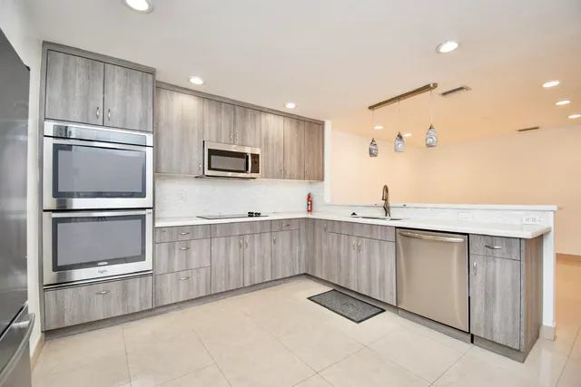 a kitchen with granite countertop a refrigerator and a sink