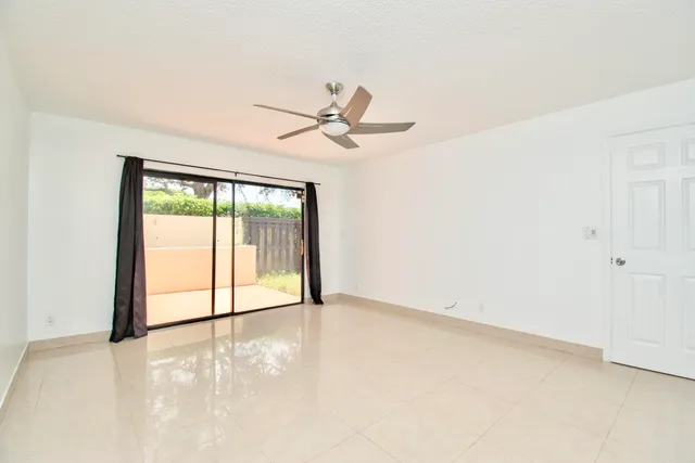 an empty room with a ceiling fan and a window