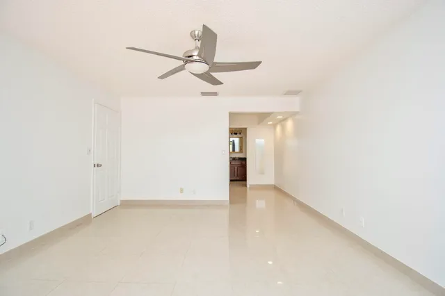 an empty room with a ceiling fan and a window
