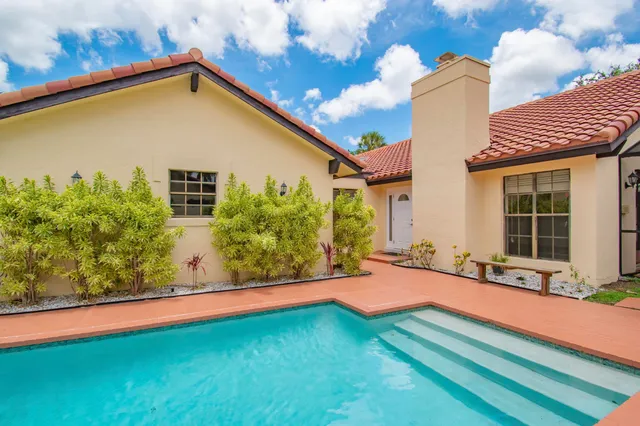 a view of a house with pool and sitting area
