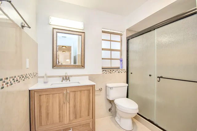 a bathroom with a toilet sink and a mirror