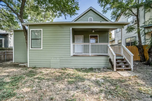 a view of a house with a yard and wooden fence