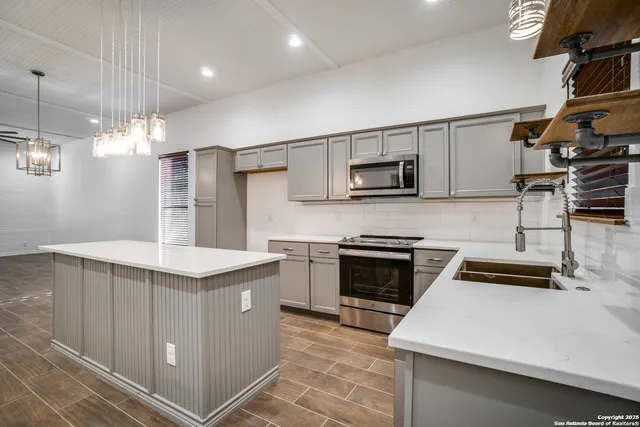 a kitchen that has a sink and a stove in it