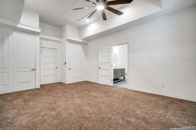 an empty room with closet and a ceiling fan