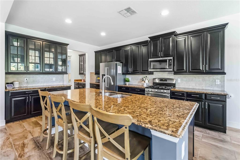 1004 Vinsetta Circle Winter Garden, FL 34787 - Photo 20 of 64 a kitchen with stainless steel appliances granite countertop a stove top oven a sink a refrigerator and a granite counter tops