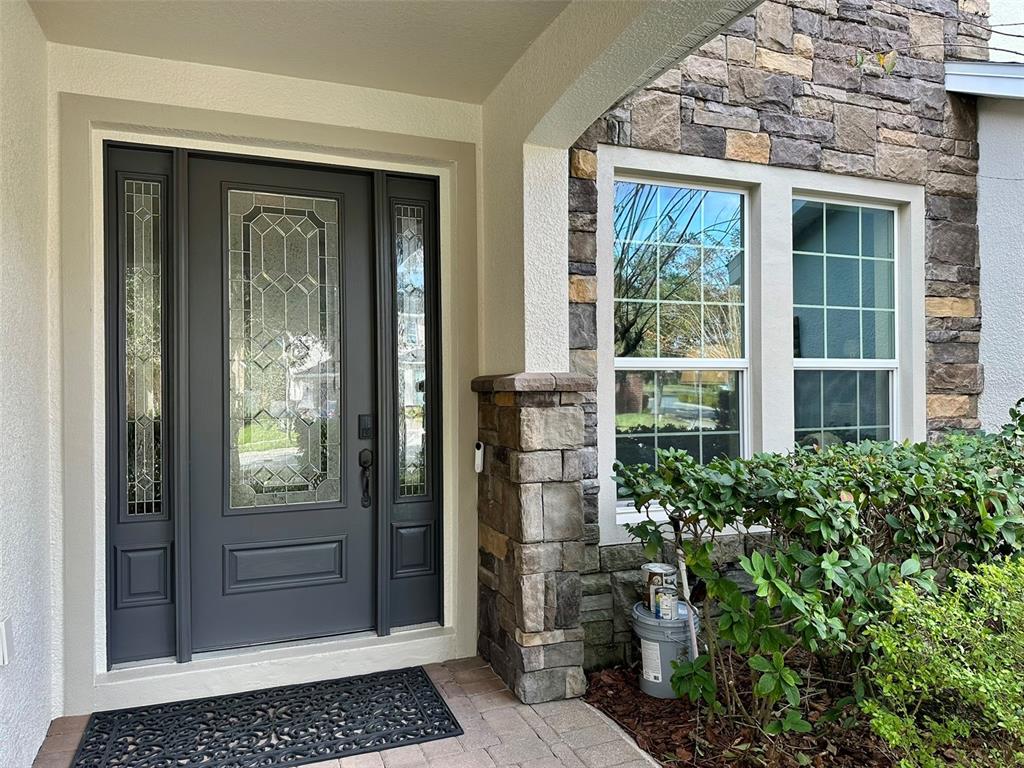 1004 Vinsetta Circle Winter Garden, FL 34787 - Photo 3 of 64 front view of a brick house with a bench in front of door