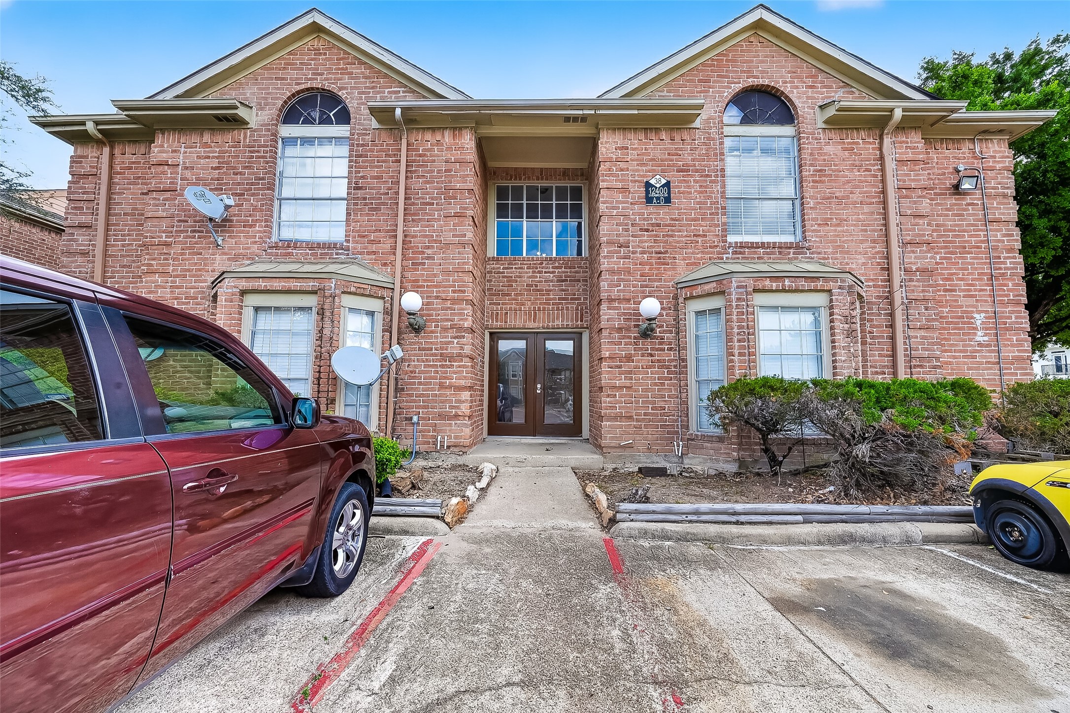 a front view of a house with garden and parking