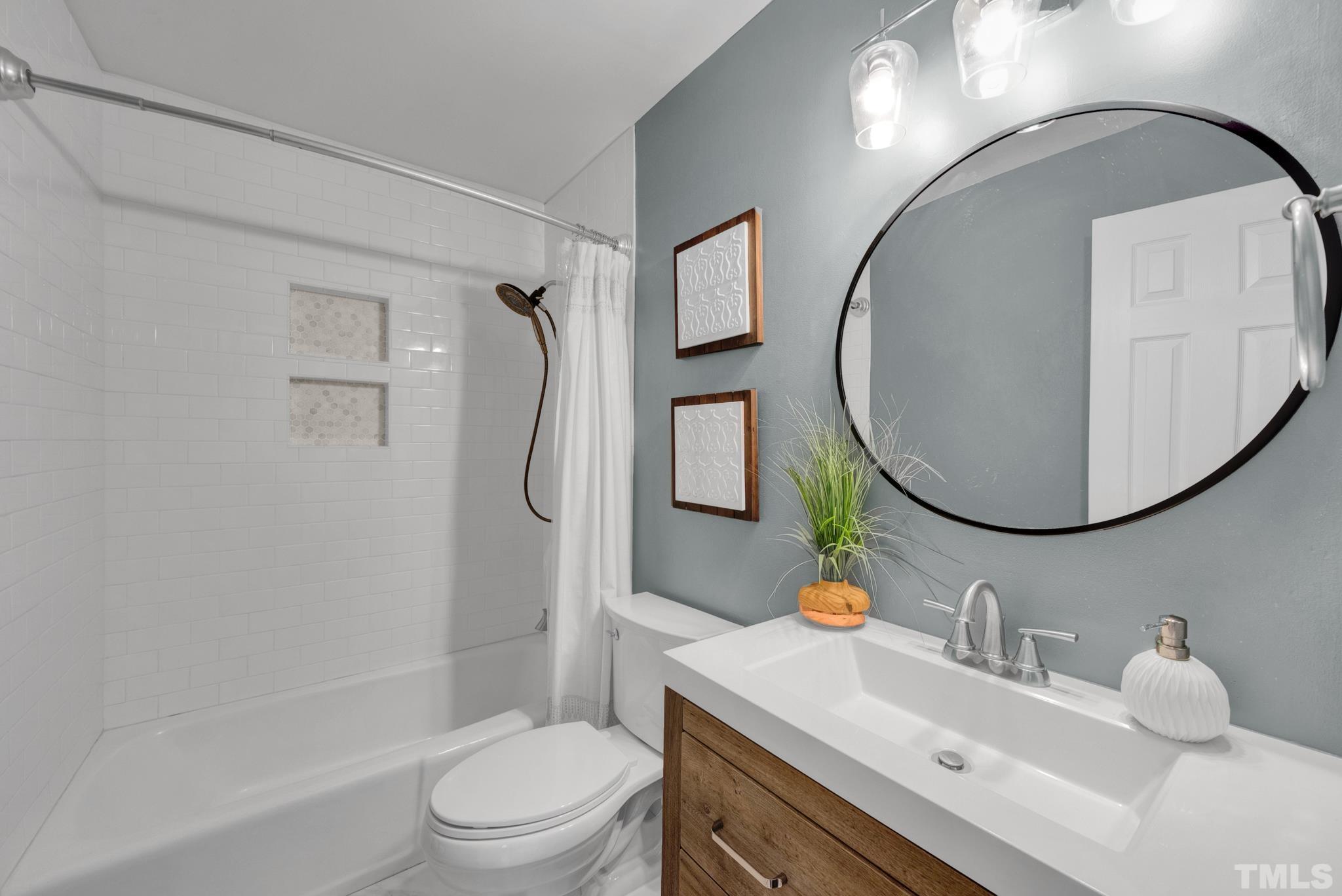 1113 Mockingbird Drive Raleigh, NC 27615 - Photo 13 of 25 a bathroom with a sink a toilet and a mirror