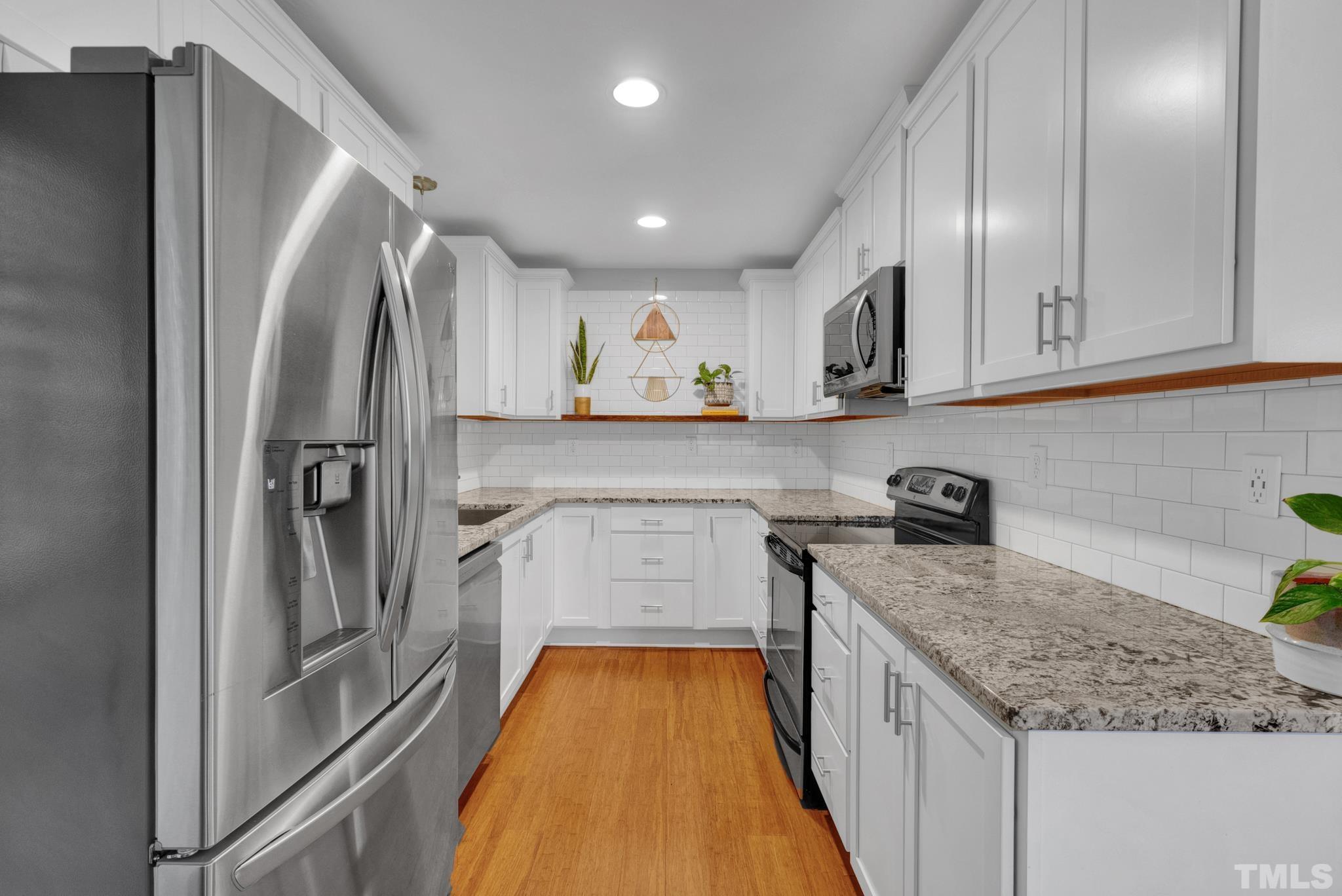 1113 Mockingbird Drive Raleigh, NC 27615 - Photo 8 of 25 a kitchen with stainless steel appliances granite countertop a refrigerator and a sink