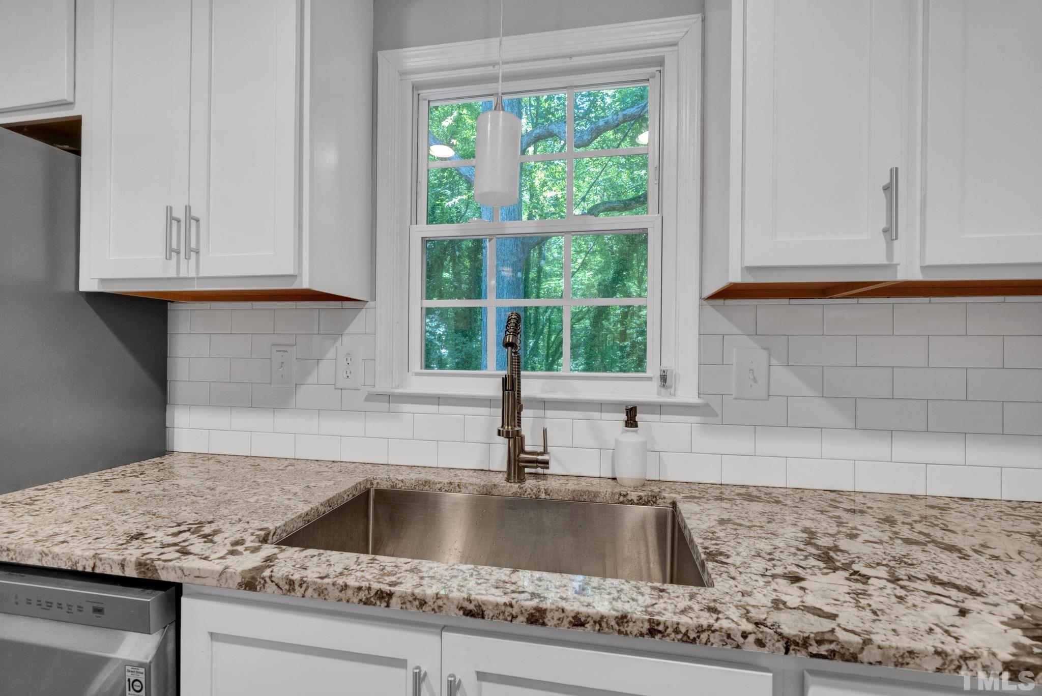 1113 Mockingbird Drive Raleigh, NC 27615 - Photo 10 of 25 a kitchen with granite countertop a sink and a window