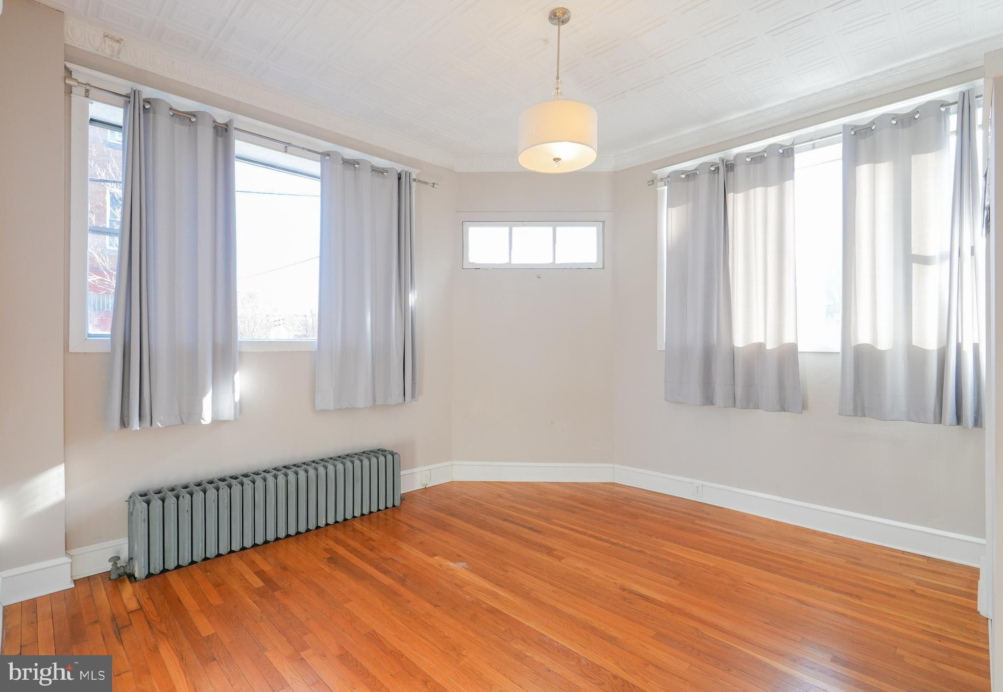 1601 Jackson Street, Unit 1 Philadelphia, PA 19145 - Photo 11 of 16 a view of an empty room with wooden floor and a window
