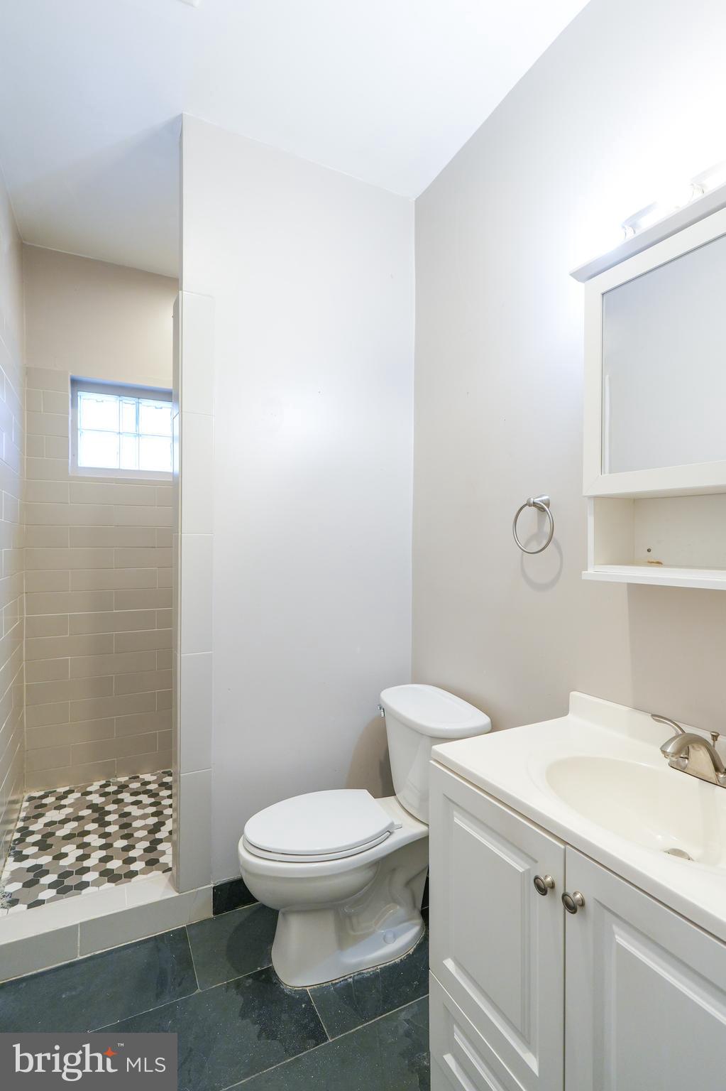 1601 Jackson Street, Unit 1 Philadelphia, PA 19145 - Photo 12 of 16 a white toilet sitting next to a bathroom sink