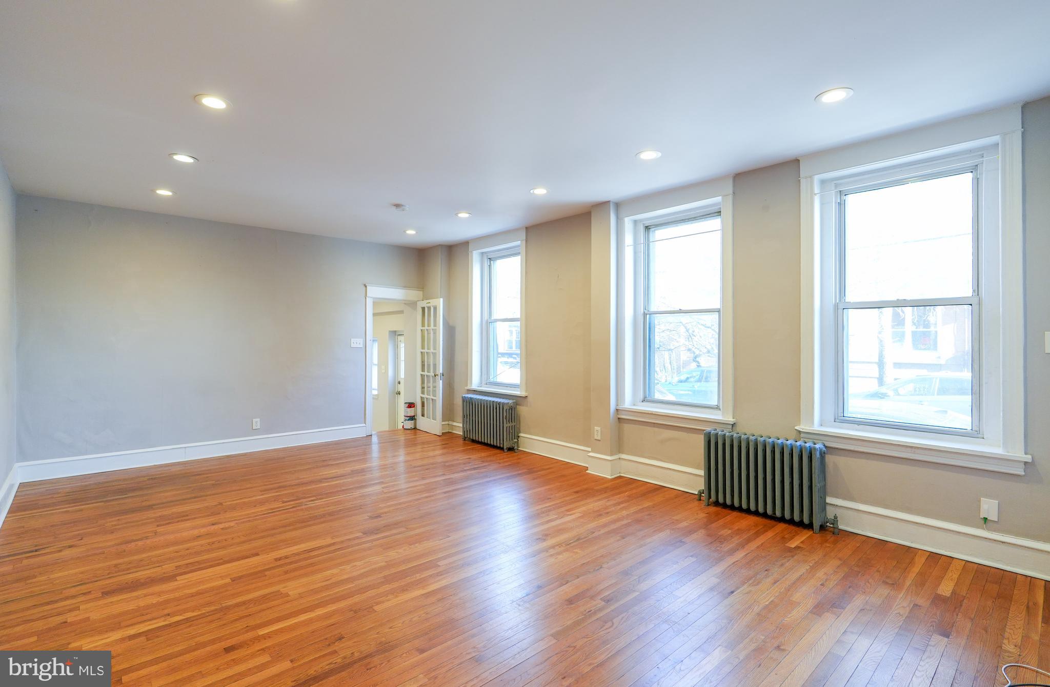 1601 Jackson Street, Unit 1 Philadelphia, PA 19145 - Photo 5 of 16 a view of an empty room with wooden floor and a window