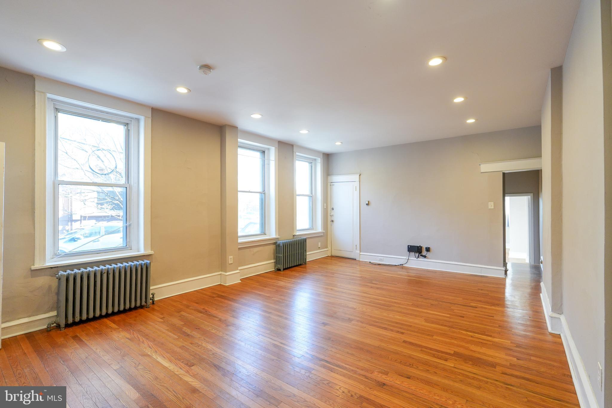 1601 Jackson Street, Unit 1 Philadelphia, PA 19145 - Photo 7 of 16 a view of an empty room with wooden floor and a window