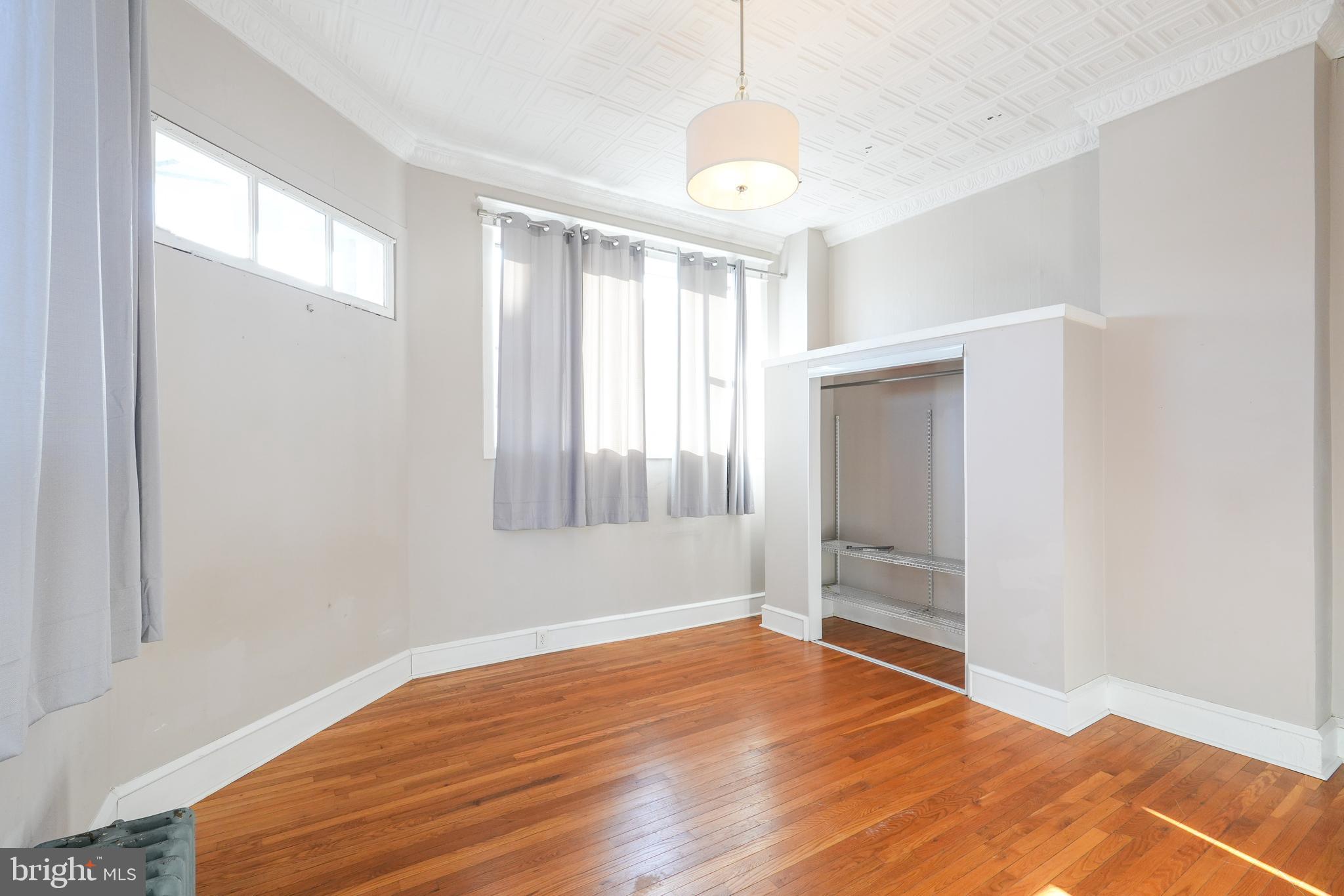 1601 Jackson Street, Unit 1 Philadelphia, PA 19145 - Photo 10 of 16 an empty room with wooden floor and windows