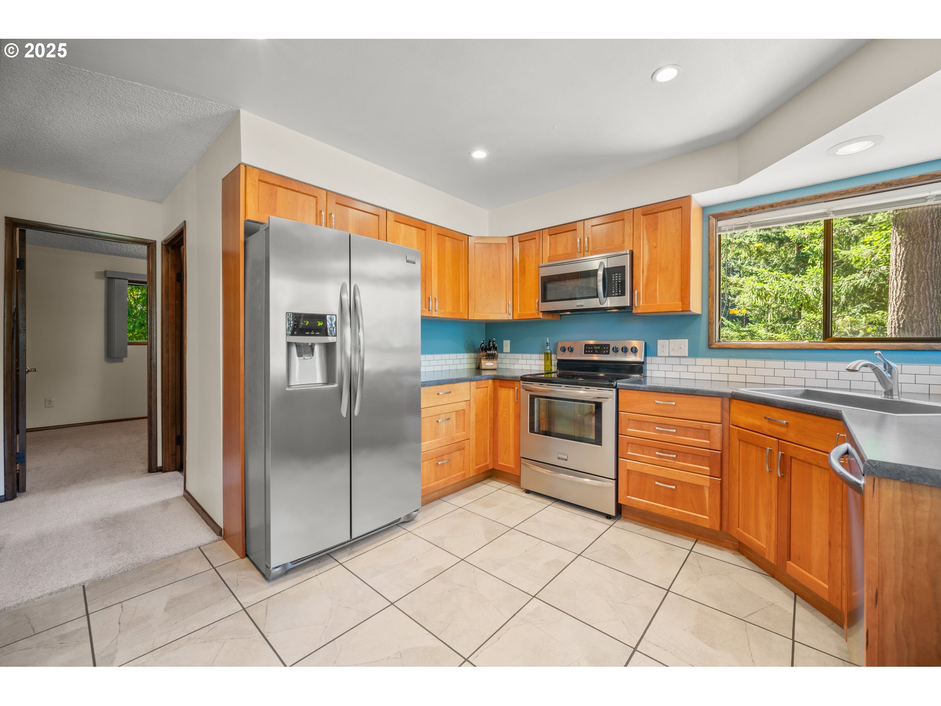 9420 Southeast Carnaby Way Happy Valley, OR 97086 - Photo 12 of 43 a kitchen with stainless steel appliances granite countertop a refrigerator and a sink