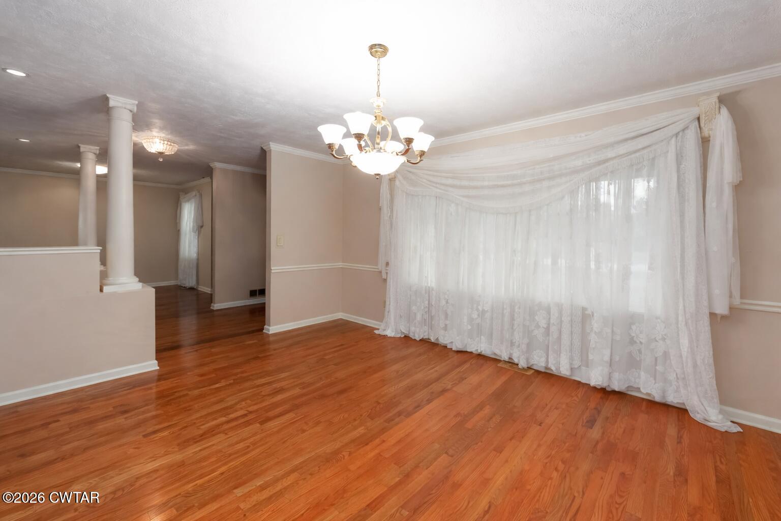 812 Pipkin Road Jackson, TN 38305 - Photo 25 of 62 a view of an empty room with wooden floor and a chandelier