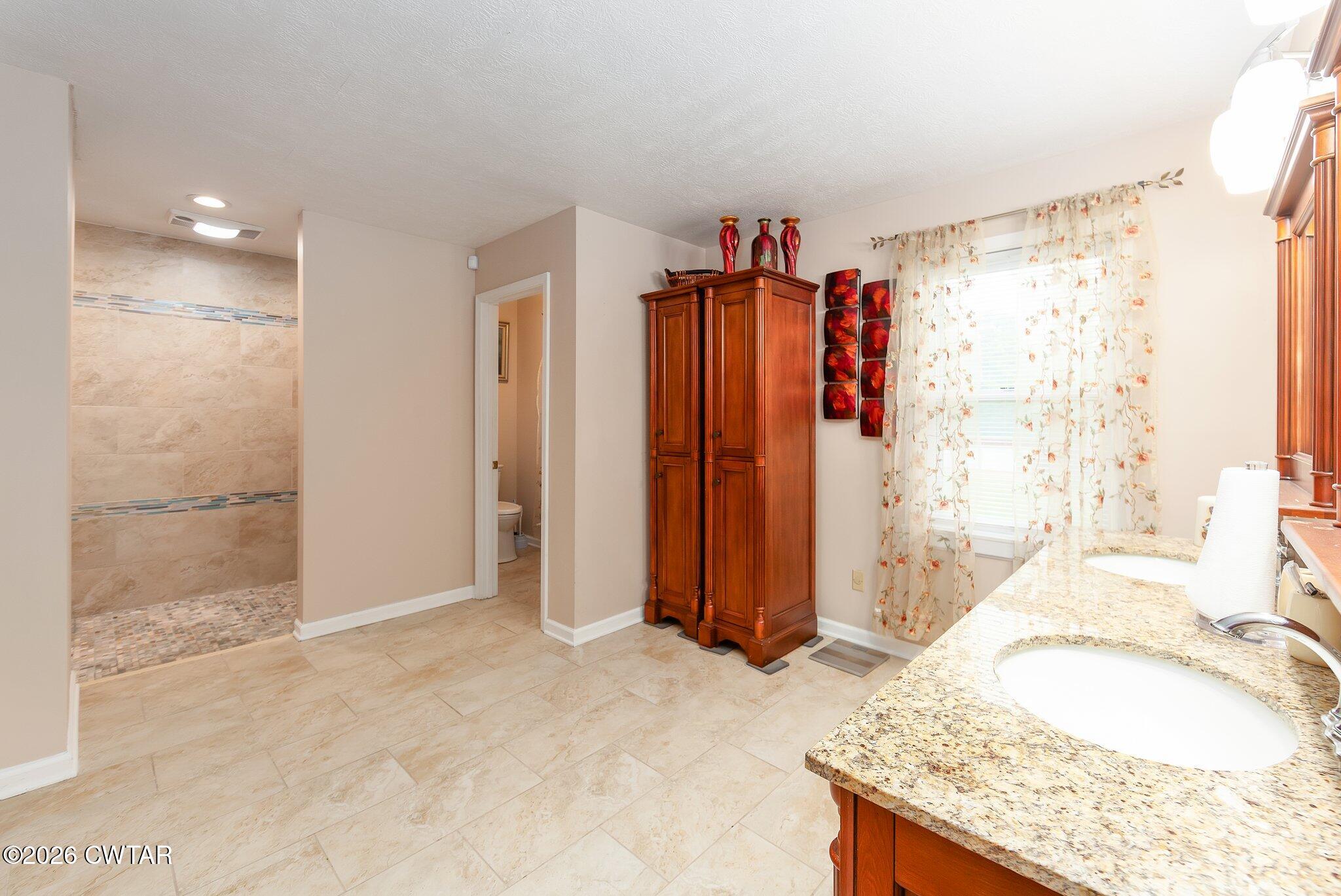 812 Pipkin Road Jackson, TN 38305 - Photo 33 of 62 a bathroom with a granite countertop sink and a shower