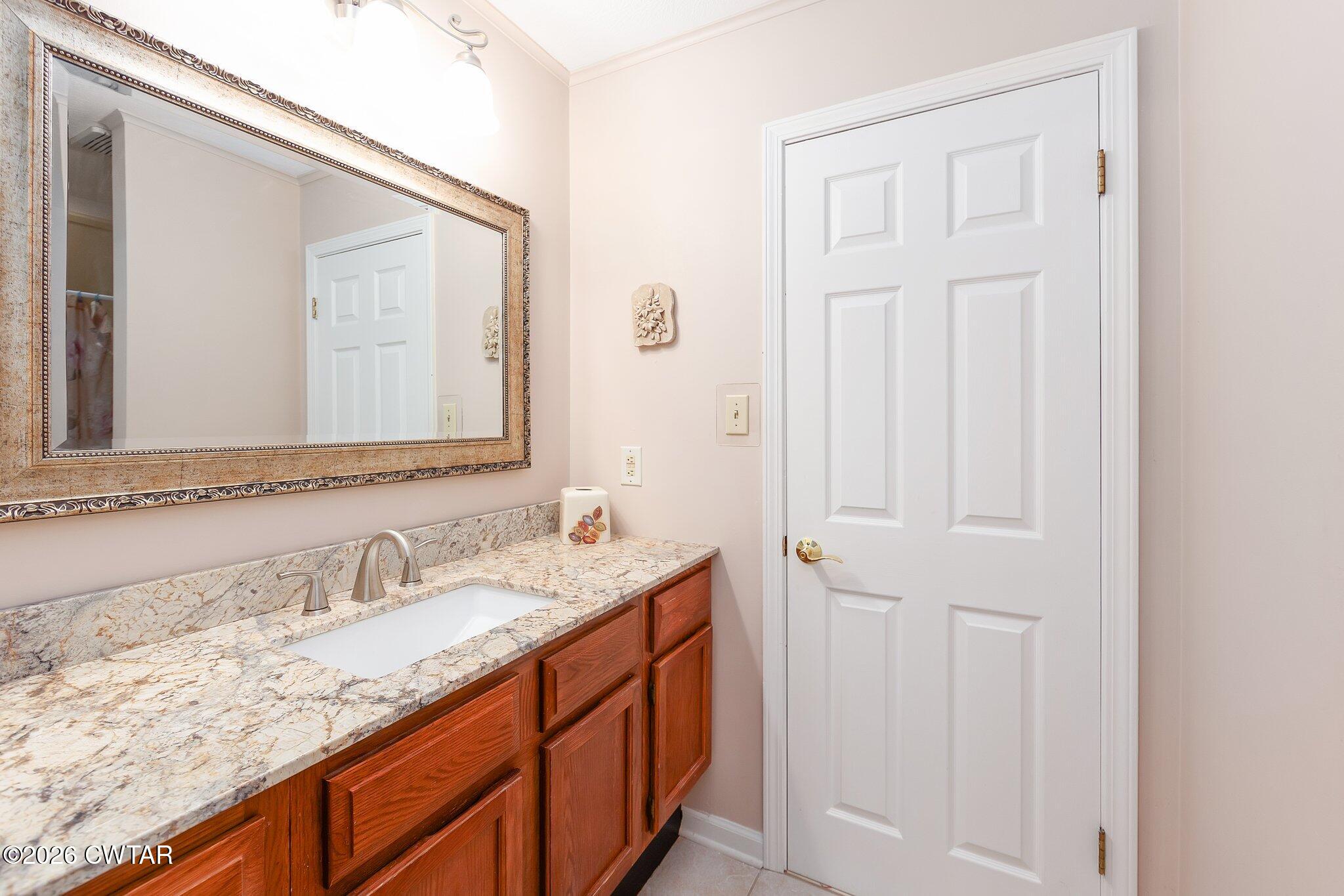 812 Pipkin Road Jackson, TN 38305 - Photo 49 of 62 a bathroom with a granite countertop sink and a mirror