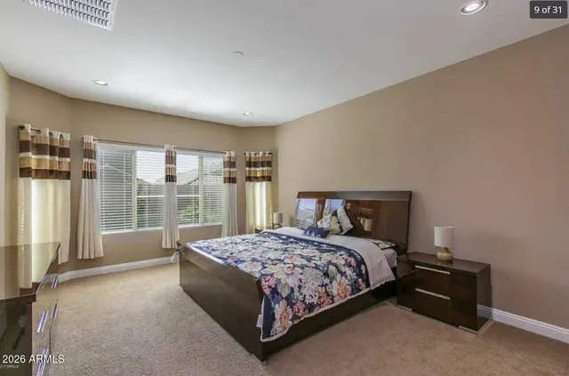 a bedroom with a bed lamp and a large window