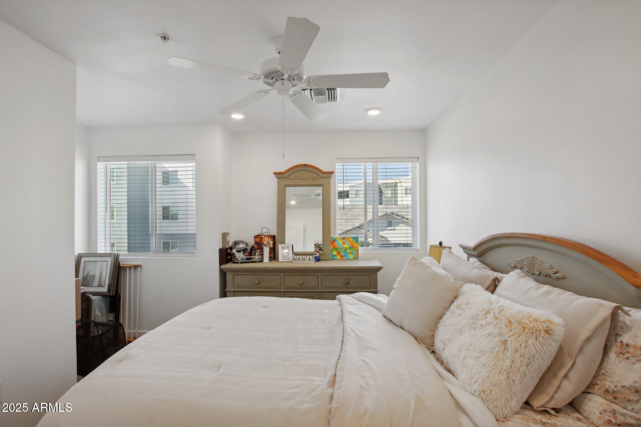 12925 West Greenway Road, Unit 5 El Mirage, AZ 85335 - Photo 11 of 30 a bedroom with a large bed and wooden floor