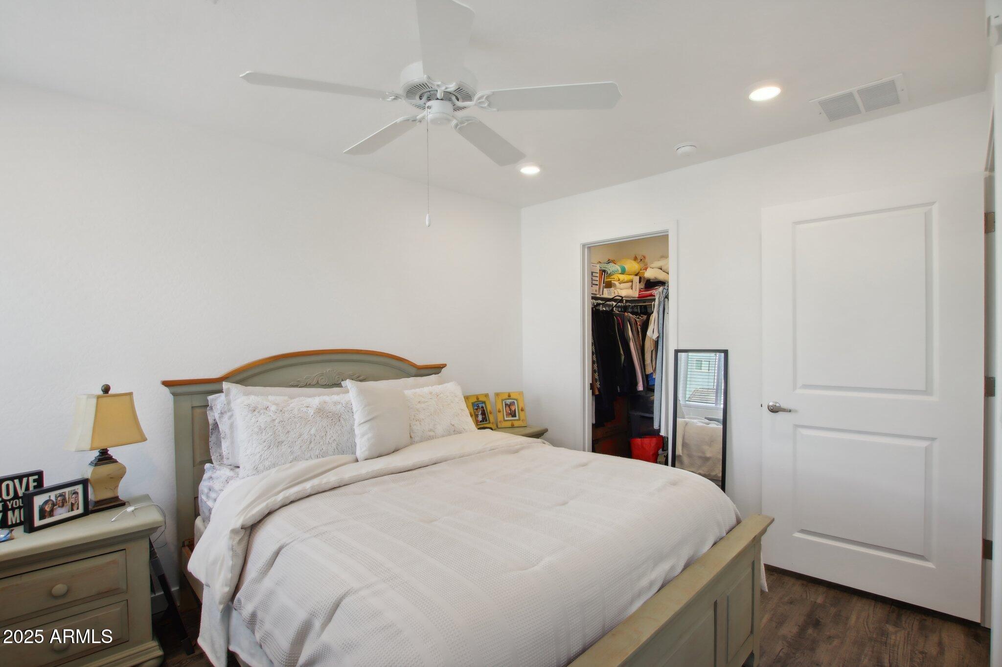 12925 West Greenway Road, Unit 5 El Mirage, AZ 85335 - Photo 12 of 30 a bedroom with a bed and a chandelier