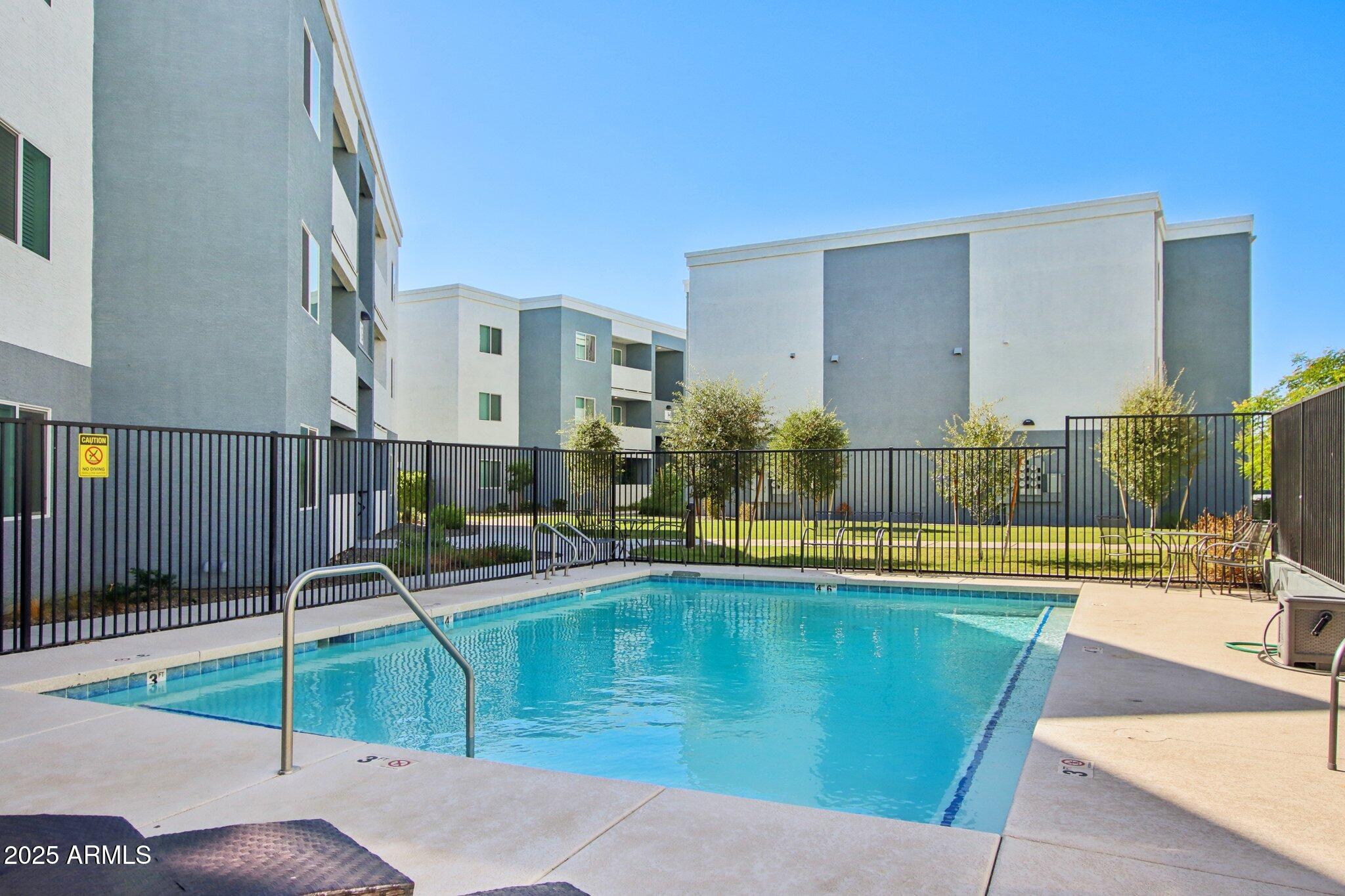 12925 West Greenway Road, Unit 5 El Mirage, AZ 85335 - Photo 20 of 30 a swimming pool with outdoor seating and yard