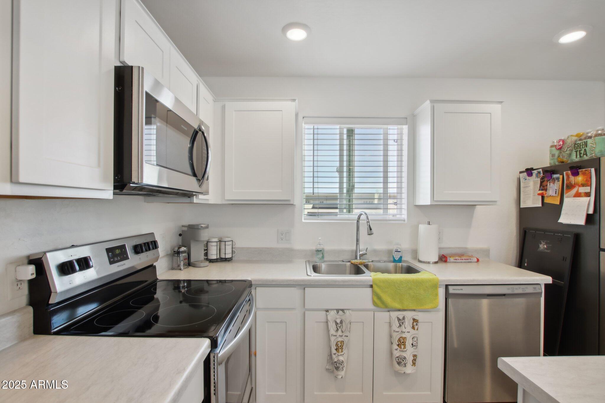 12925 West Greenway Road, Unit 5 El Mirage, AZ 85335 - Photo 8 of 30 a kitchen that has a sink a stove and cabinets