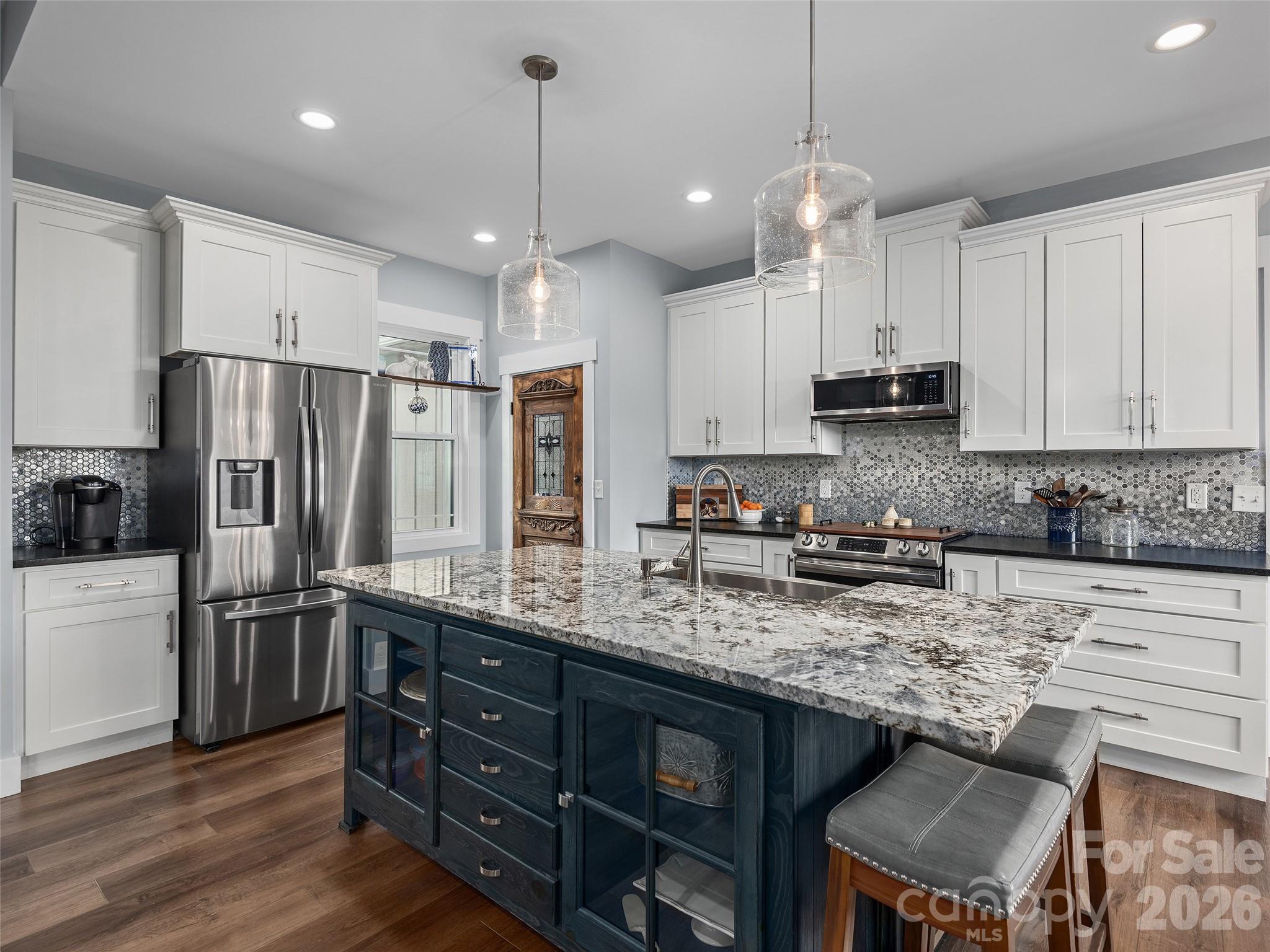 3244 Lake Adger Parkway Mill Spring, NC 28756 - Photo 12 of 44 a kitchen with stainless steel appliances granite countertop a sink refrigerator and cabinets